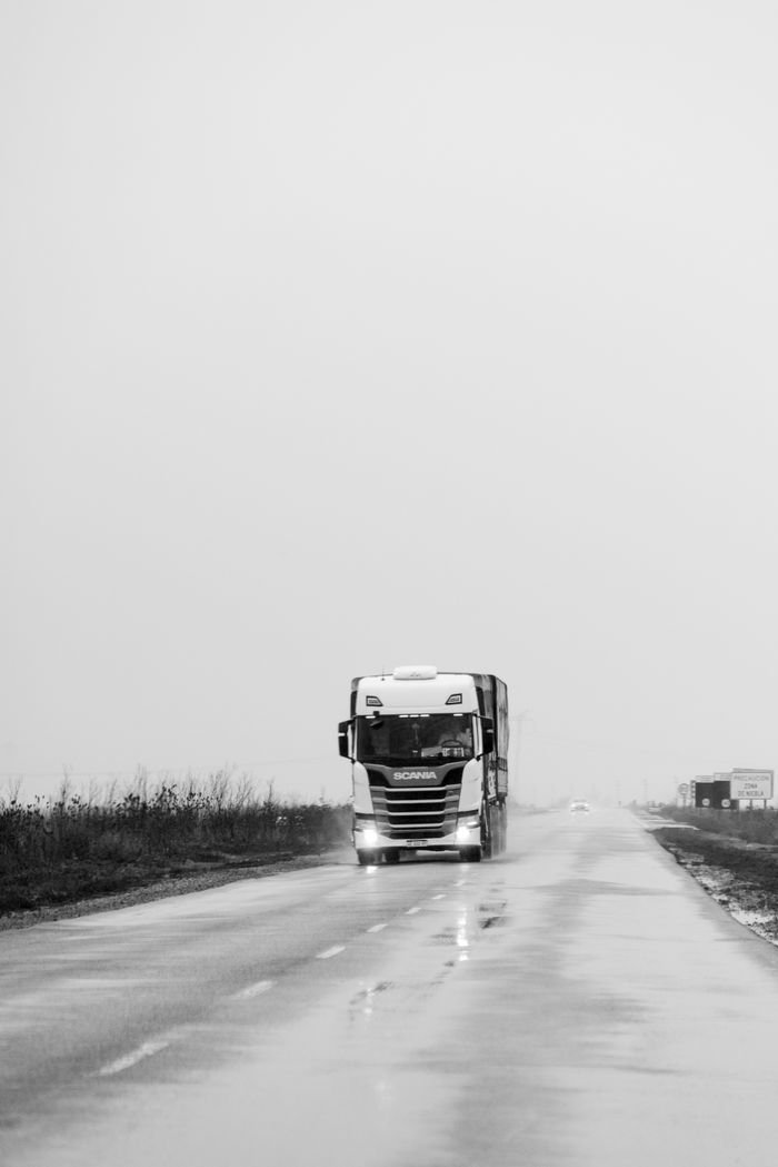 Monochrome image of a truck driving on a rainy road in Carlos Spegazzini, Buenos Aires.